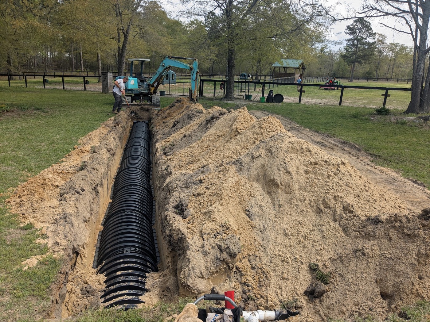 Fresh corrugated drainfield lines laid in a long sandy trench