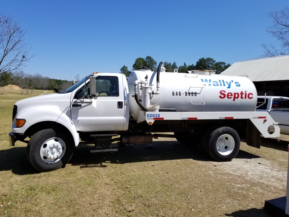 The Wally's Septic white vacuum tank truck, hand lettered in blue and red, parked on the grass